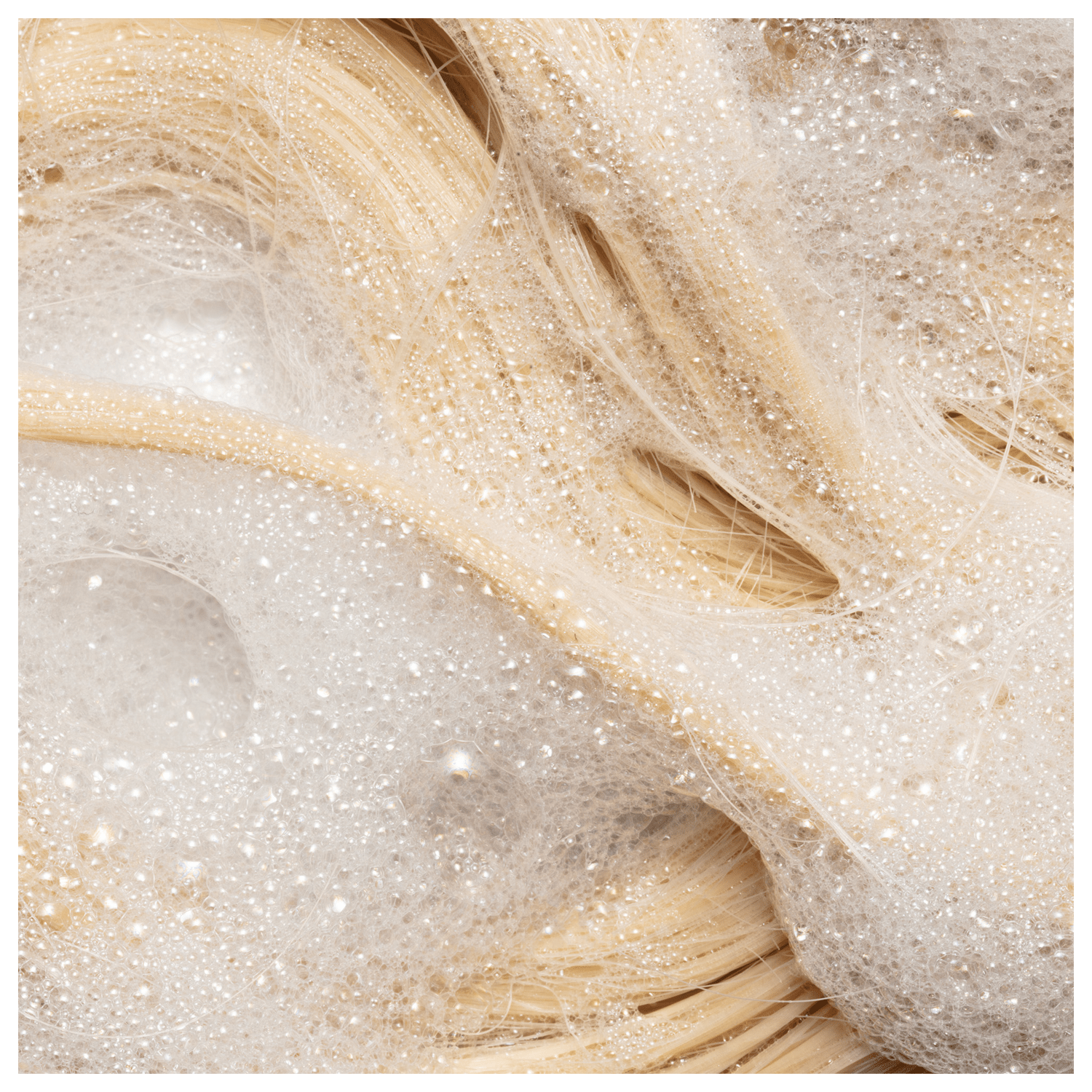 Shampoo da linha Blond Revolution da marca TRUSS. Imagem com cabelos sendo limpos.