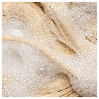 Shampoo da linha Blond Revolution da marca TRUSS. Imagem com cabelos sendo limpos.